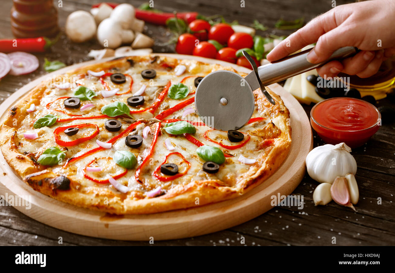 https://c8.alamy.com/comp/HXD9AJ/slicing-delicious-pizza-with-pizza-cutter-HXD9AJ.jpg