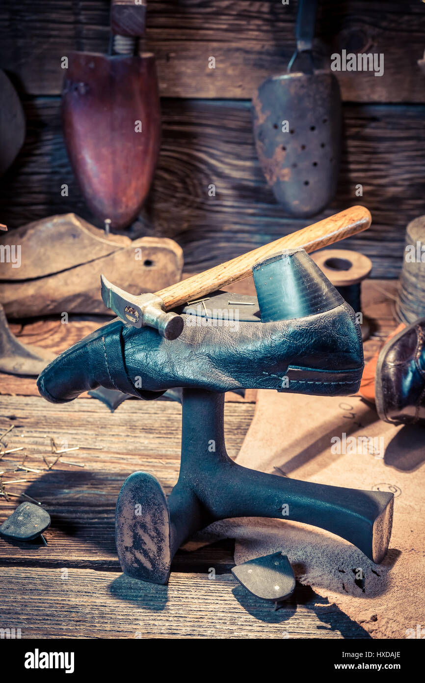 Vintage shoemaker workshop with tools, shoes and leather Stock Photo ...