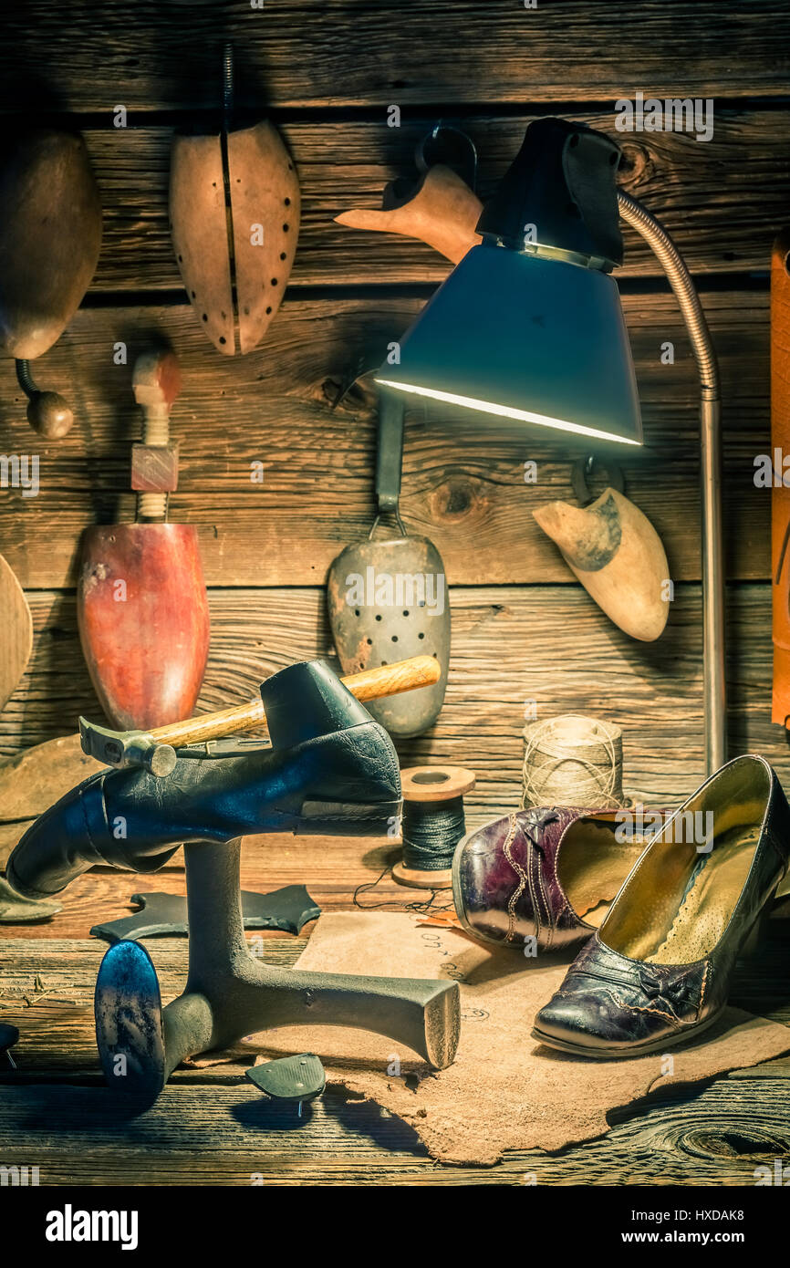 Vintage shoemaker workplace with shoes, laces and tools Stock Photo - Alamy