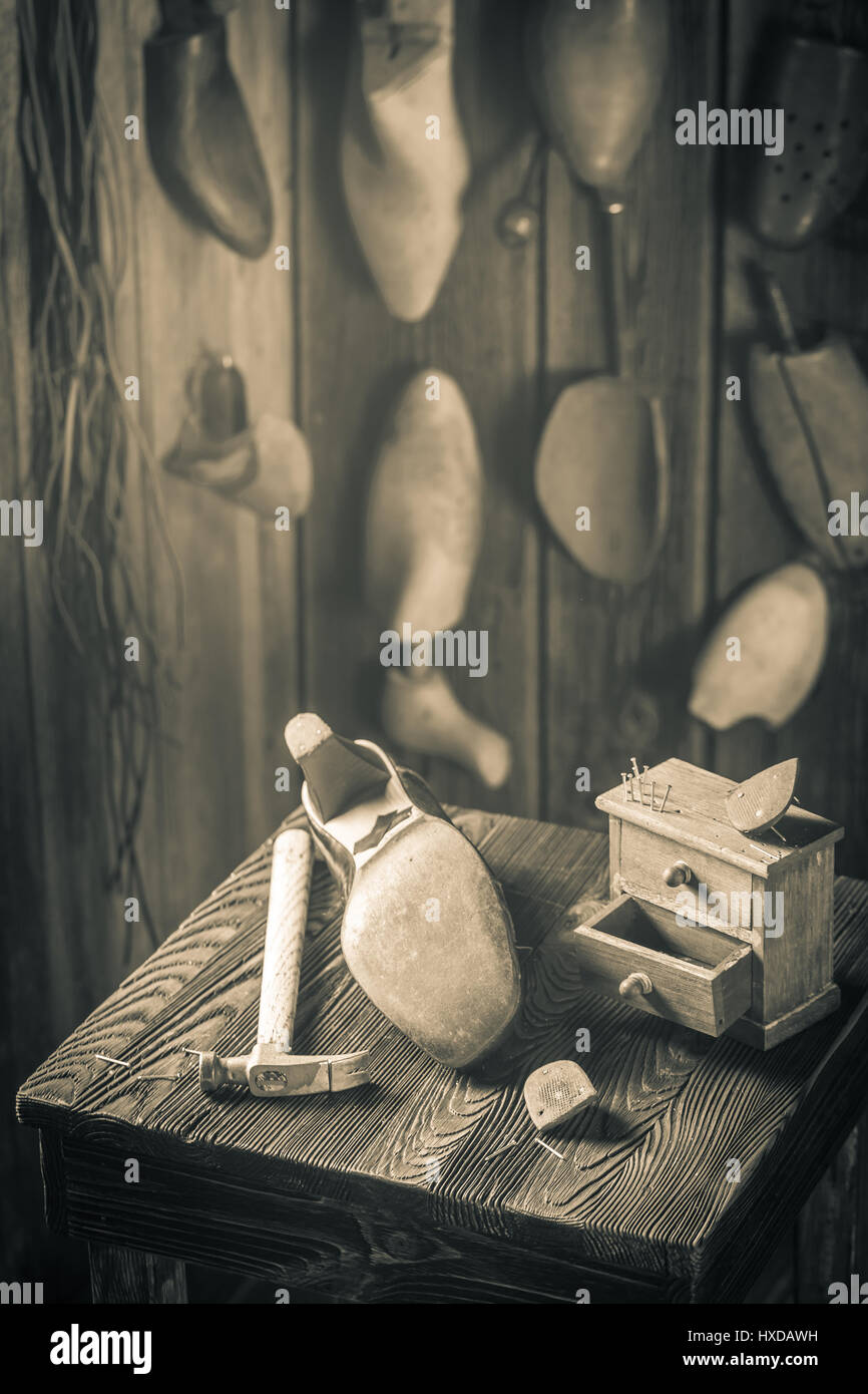 Aged shoemaker workplace with shoes, laces and tools Stock Photo - Alamy