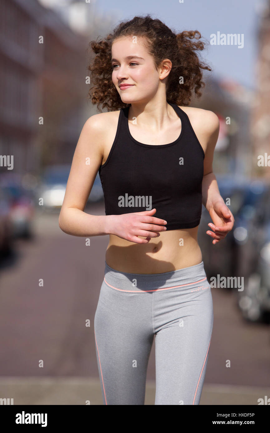 Portrait of a happy teenage girl jogging outdoors Stock Photo - Alamy