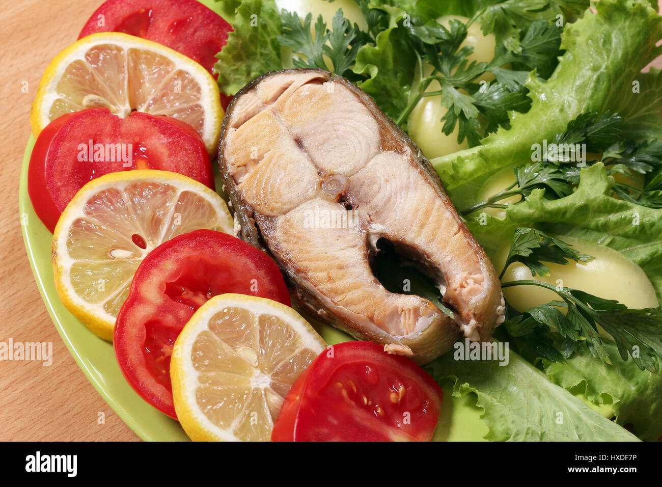 seafood salmon with lemon tomatoes and green salad Stock Photo