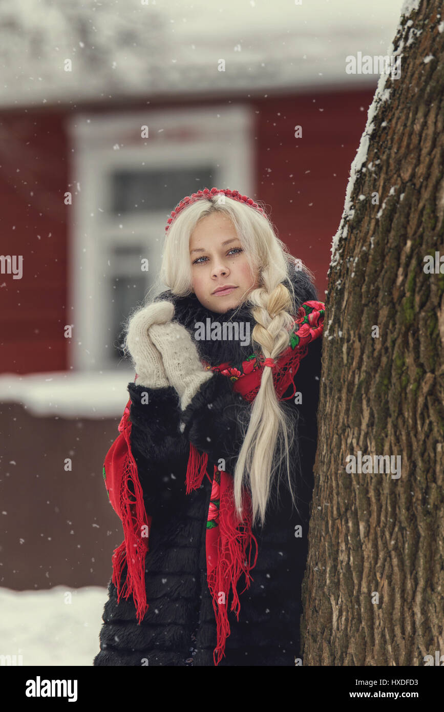 Portrait of a young caucasian woman in russian style on a strong frost in a winter snowy day. Russian model girl in traditional dress Stock Photo