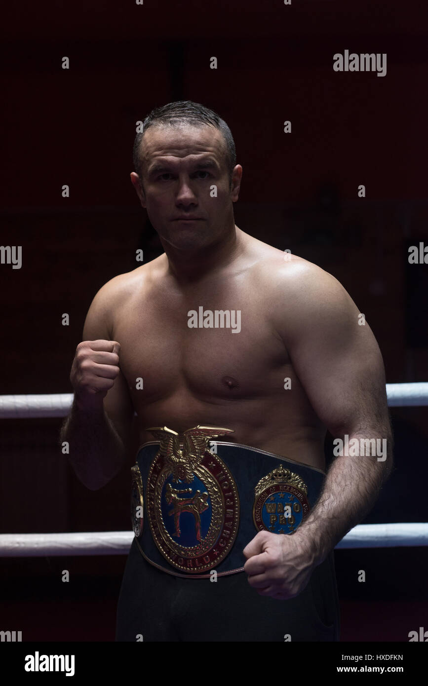 portrait of muscular professional kick boxer with his championship belt