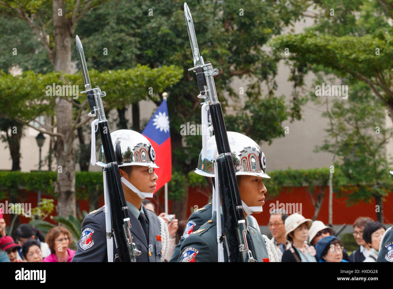 [Editorial Use Only] TAIPEI, TAIWAN: Honor guards with rifle and bayonet with tourist in the background at National Revolutionary Martyrs' Shrine Stock Photo