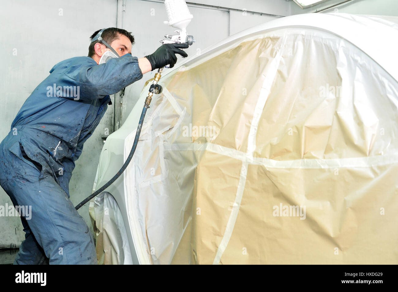 Worker painting white car. Stock Photo