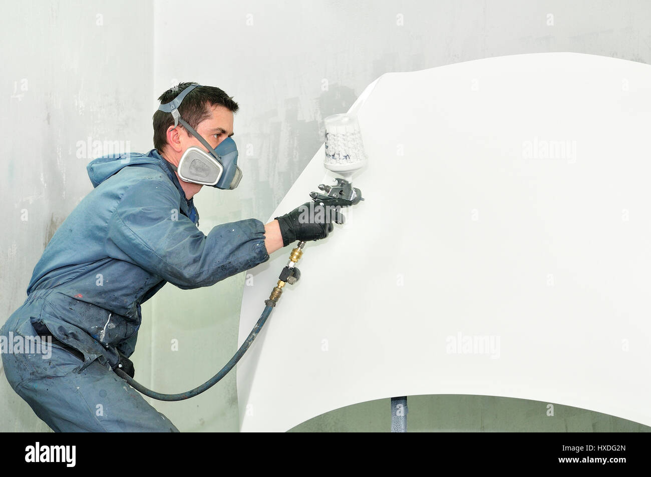 Worker painting white car. Stock Photo