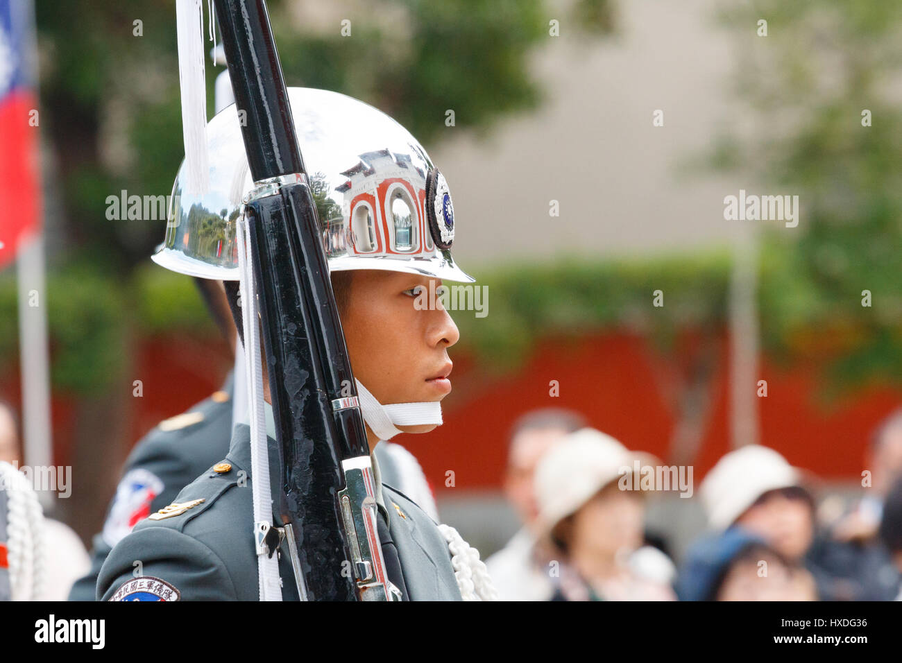 [Editorial Use Only] TAIPEI, TAIWAN: Honor guard with rifle and bayonet with tourist in the background at National Revolutionary Martyrs' Shrine Stock Photo
