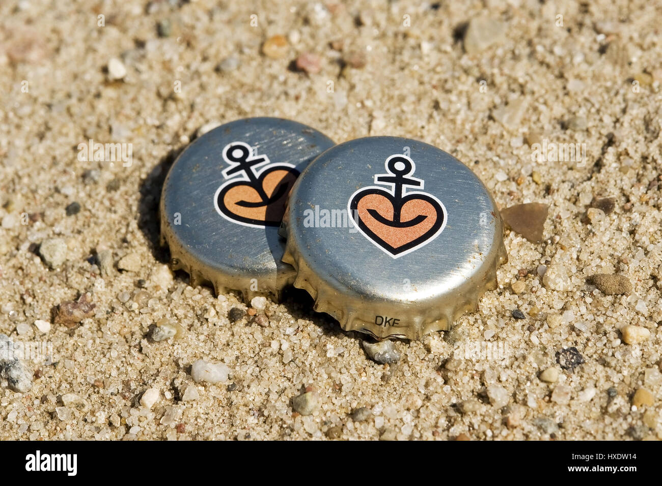 Two Astra-Kronkorken on the beach, Two Astra crown corks on the beach |, Zwei Astra-Kronkorken am Strand |Two Astra crown corks on the beach| Stock Photo
