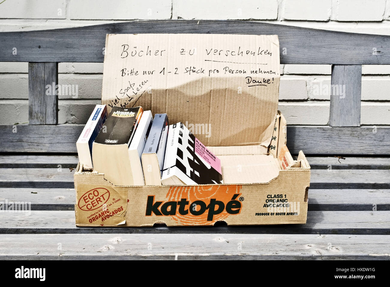 Used books in a cardboard on a wooden bank, Used books in a box on a wooden bench |, Gebrauchte B¸cher in einem Karton auf einer Holzbank | Used books Stock Photo