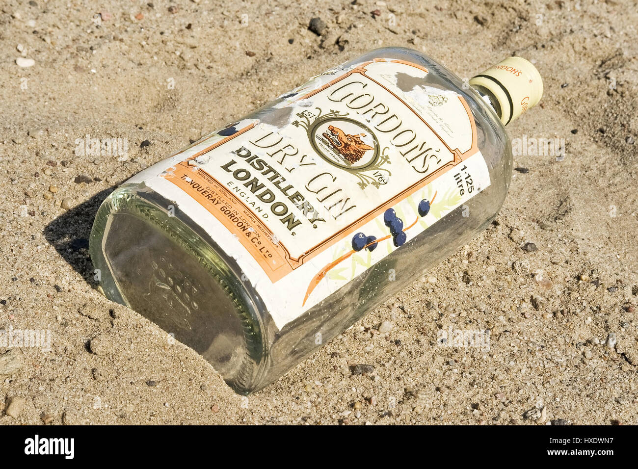 Empty gin bottle on the beach, Empty gin bottle on the beach |, Leere Ginflasche am Strand |Empty gin bottle on the beach| Stock Photo