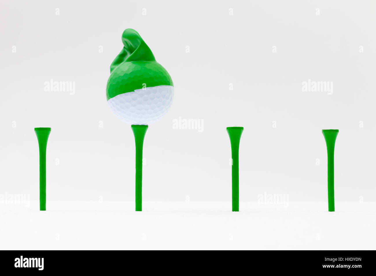 White golf balls with funny cap on the white background. Funny golf