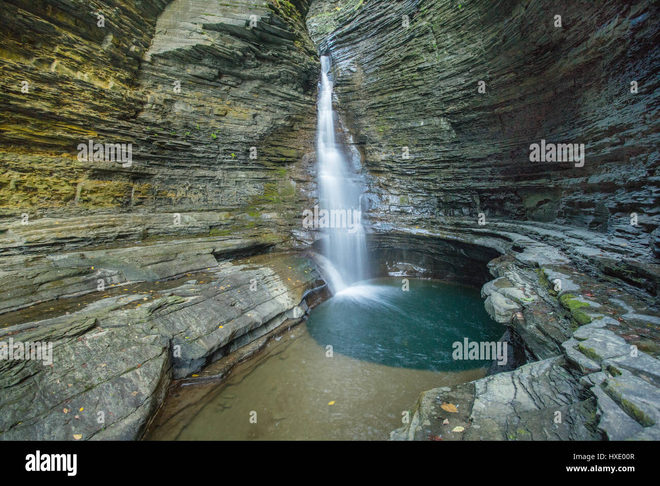 Crystal clear pool of water at the bottom of a waterfall Stock Photo