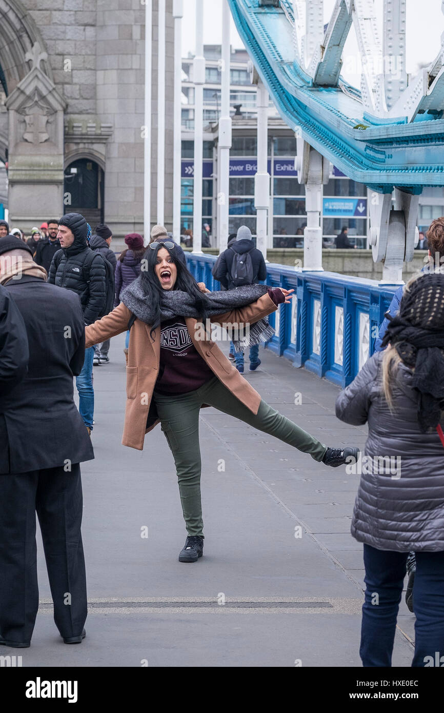 Tourist posing for a photograph on Tower Bridge in London. Stock Photo