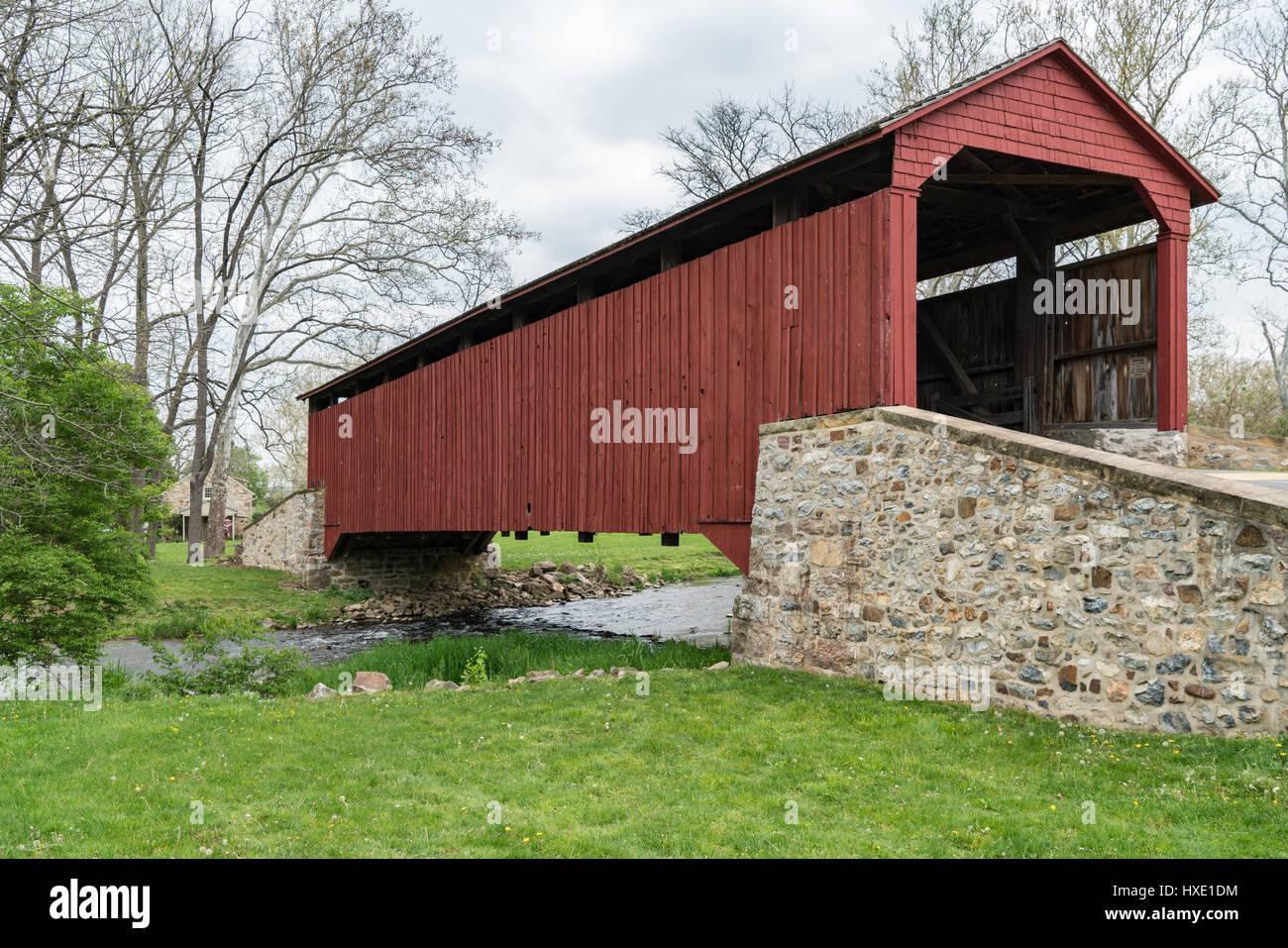 Red covered bridge in the rural countryside of Lancaster County, Pennsylvania. Stock Photo