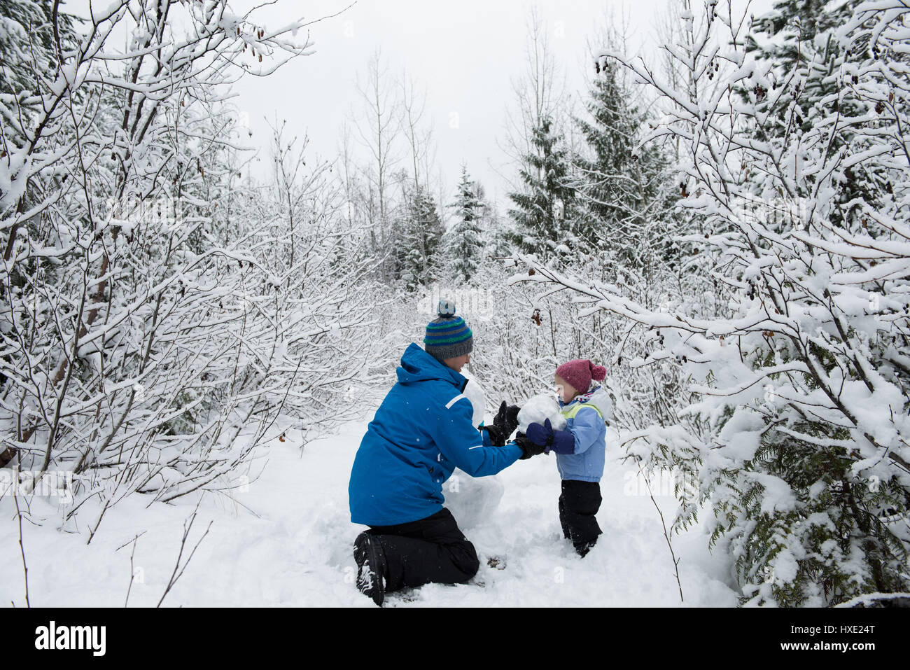 Father playing with daughter in snow on beautiful snowy day Stock Photo