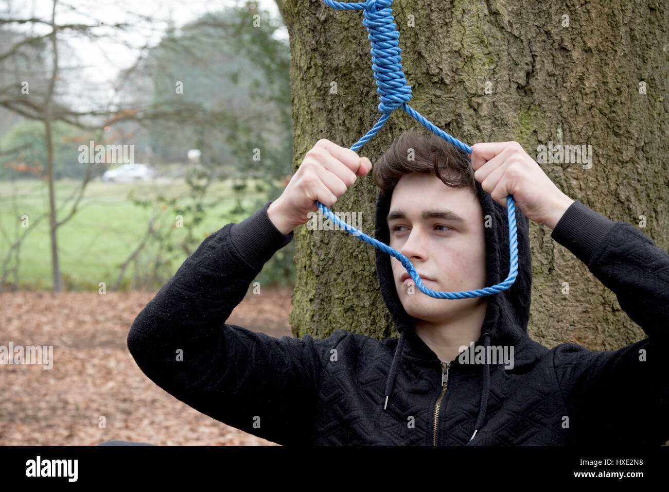 Depressed teenage boy with a hangman's noose Stock Photo