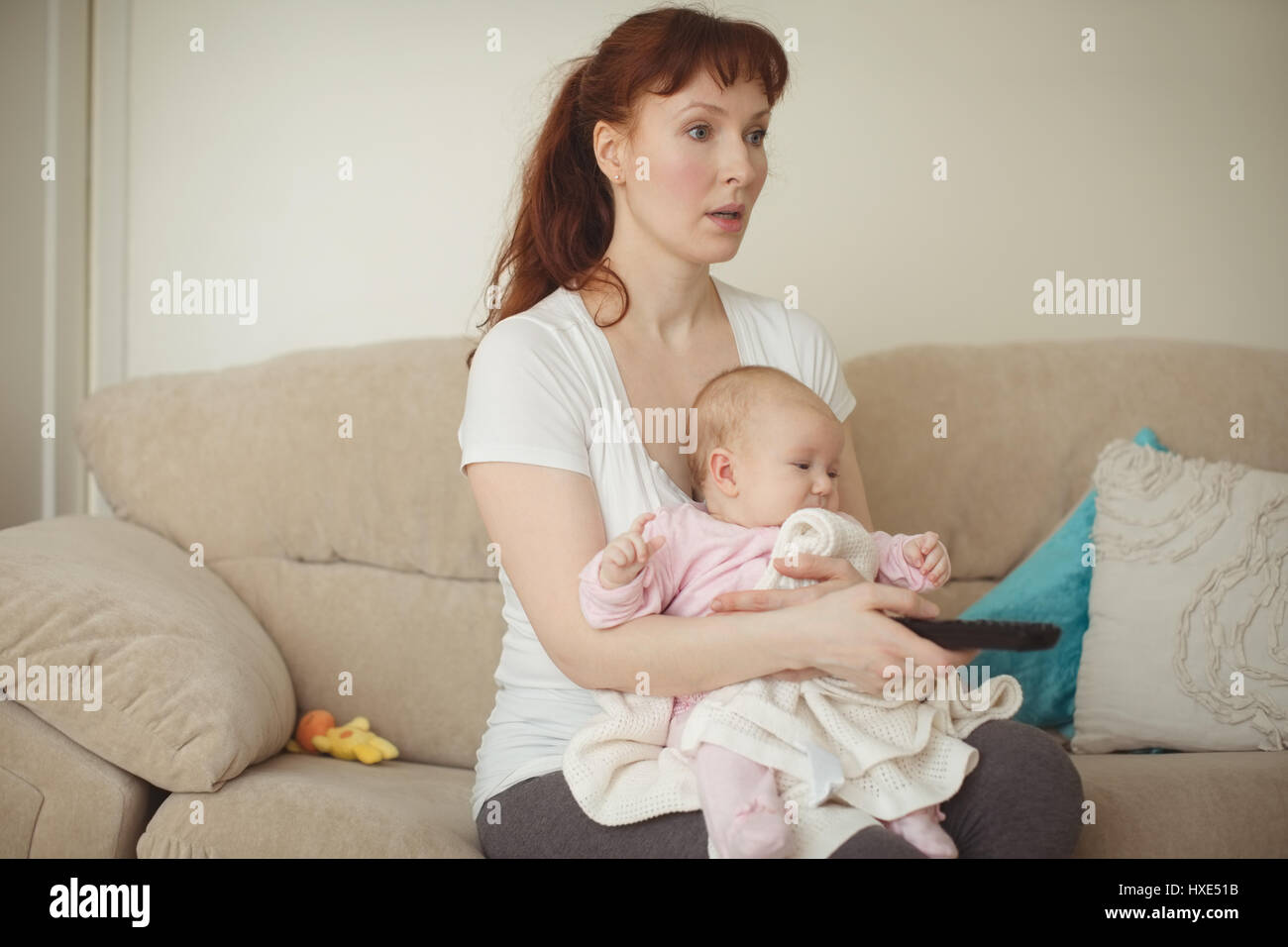 Mother watching TV while holding baby in living room Stock Photo - Alamy Mother watching TV while holding baby in living room Stock Photo - Alamy
