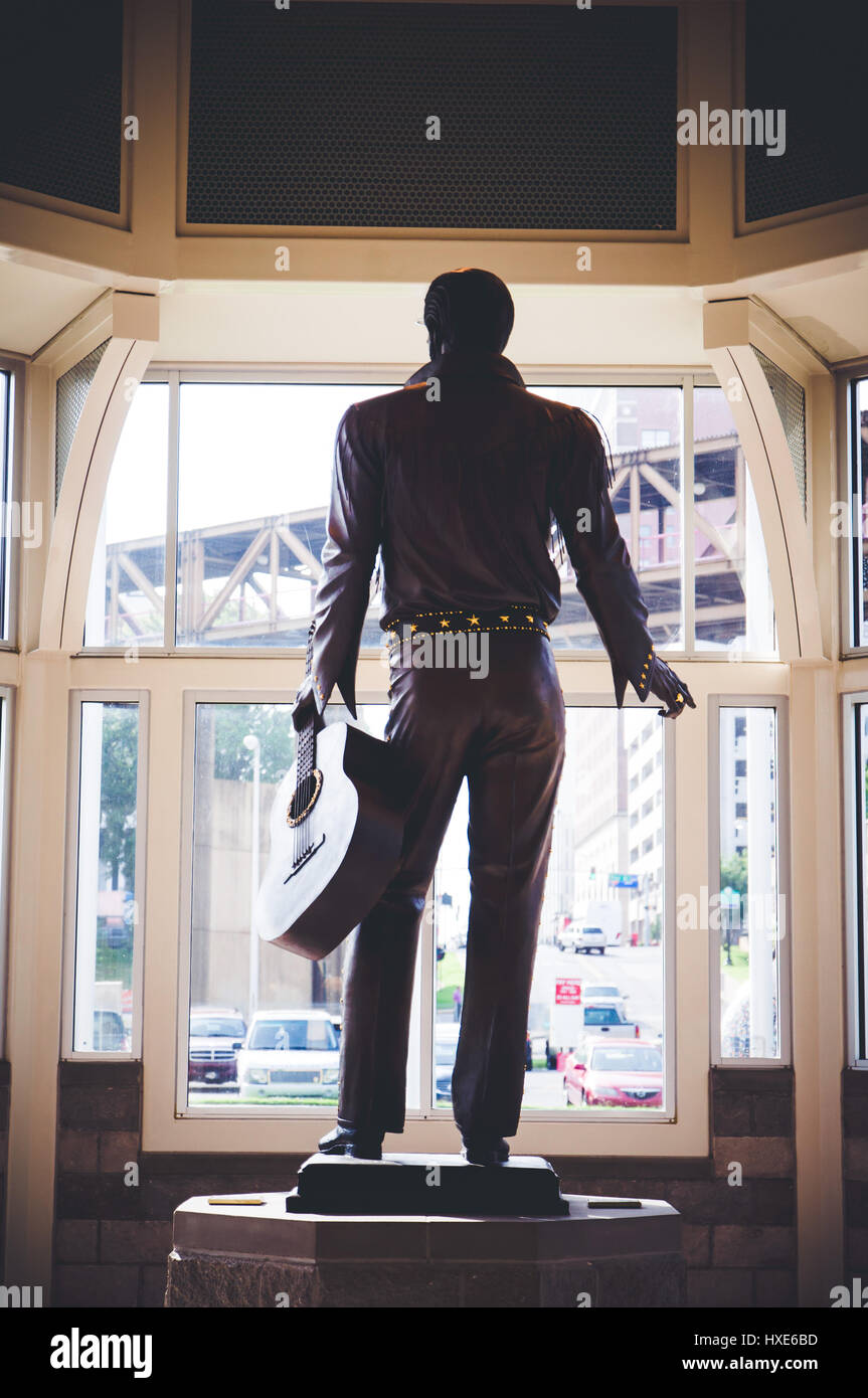 The back view of a large statue of Elvis Presley in the visitors center
