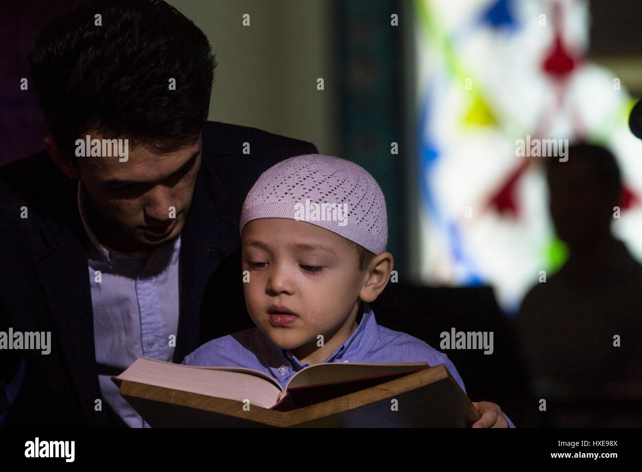 A boy reading the Koran holy book at the annual Koran festival in the Moscow Cathedral Mosque, Russia Stock Photo