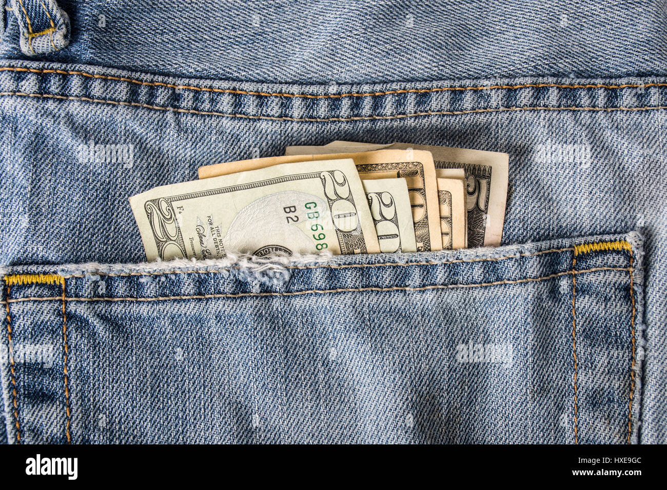 A back pocket of blue jeans showing american money fanned out. Stock Photo