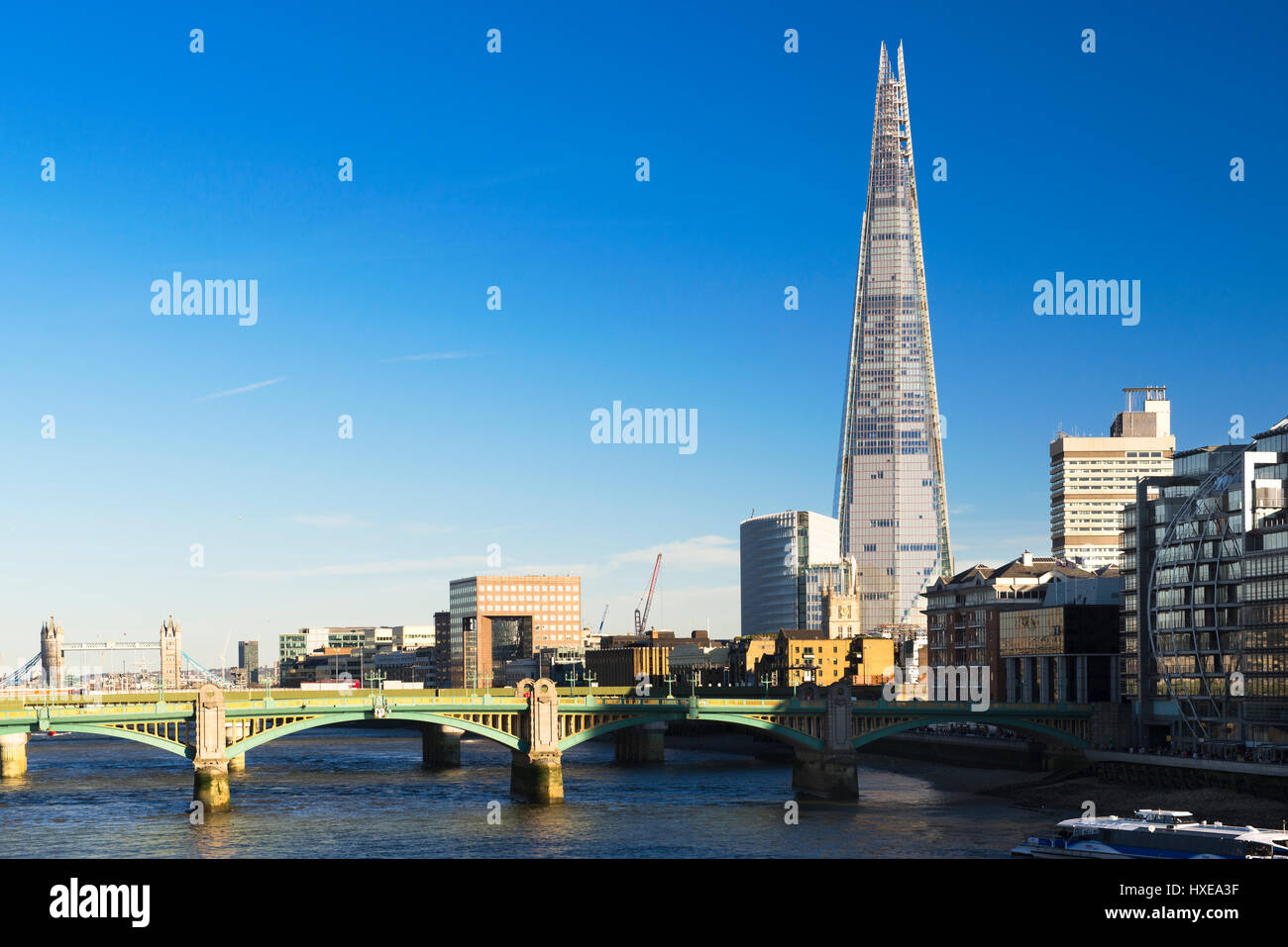 A view of the River Thames featuring The Shard (310m) with Southwark Bridge in the foreground on a bright spring afternoon, London, UK Stock Photo