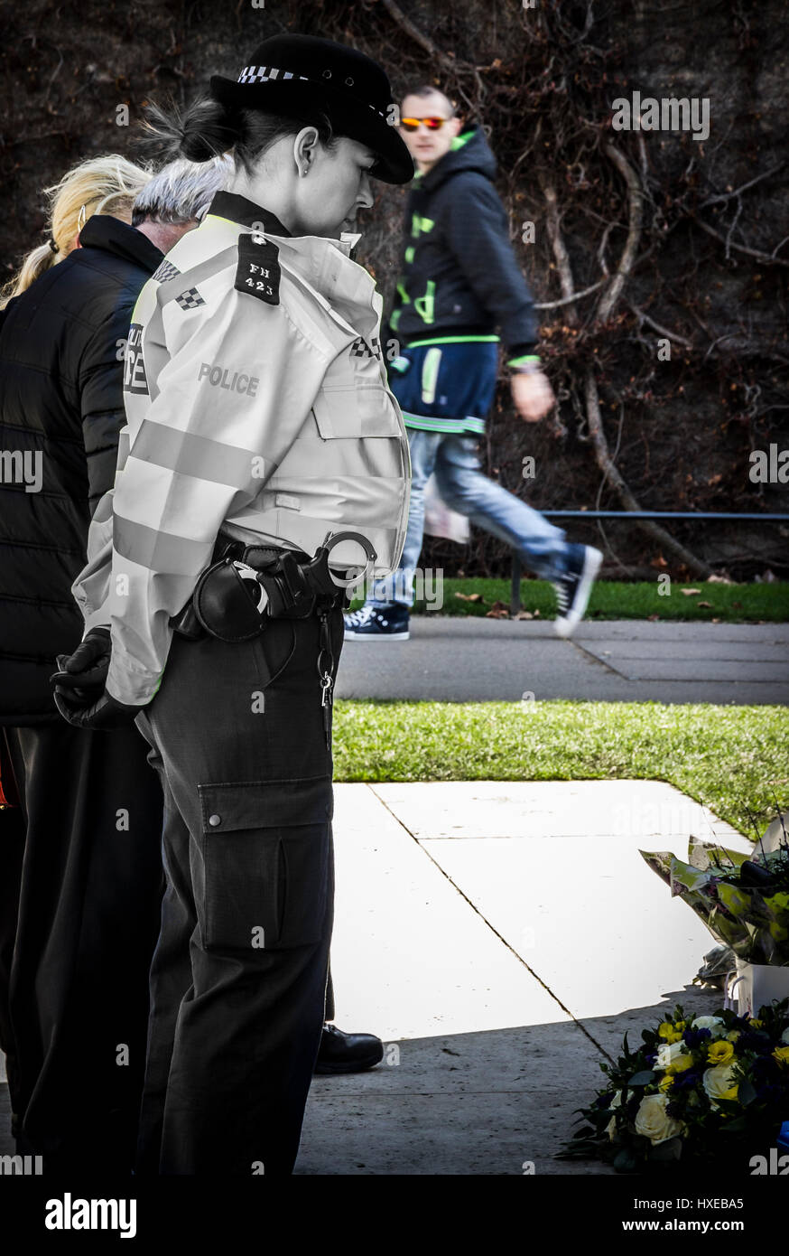 A lone female police officer in silent contemplation at the London Police Memorial, just days after the murder of a colleague. Metpolmarch17 Stock Photo