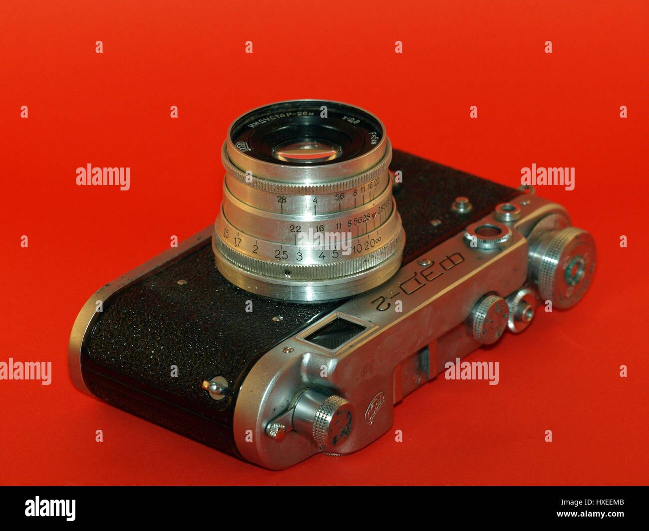 Old antique camera with leather case on red background Stock Photo