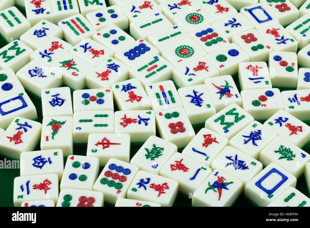 Mahjong Tiles Randomly Placed on the Mahjong Specific Green Mahjong Tabletop Stock Photo