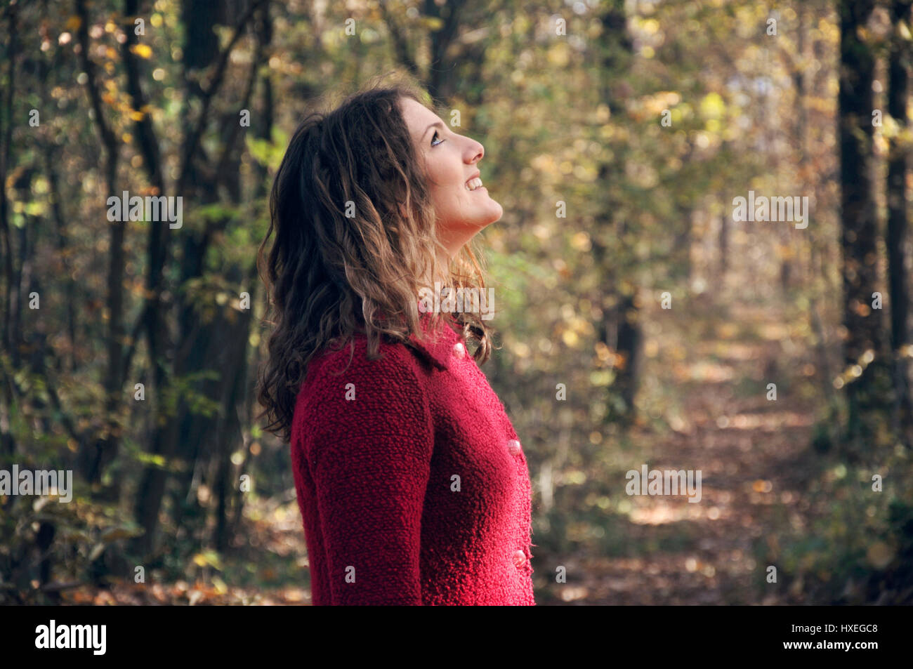 Young woman in forest looking up Stock Photo