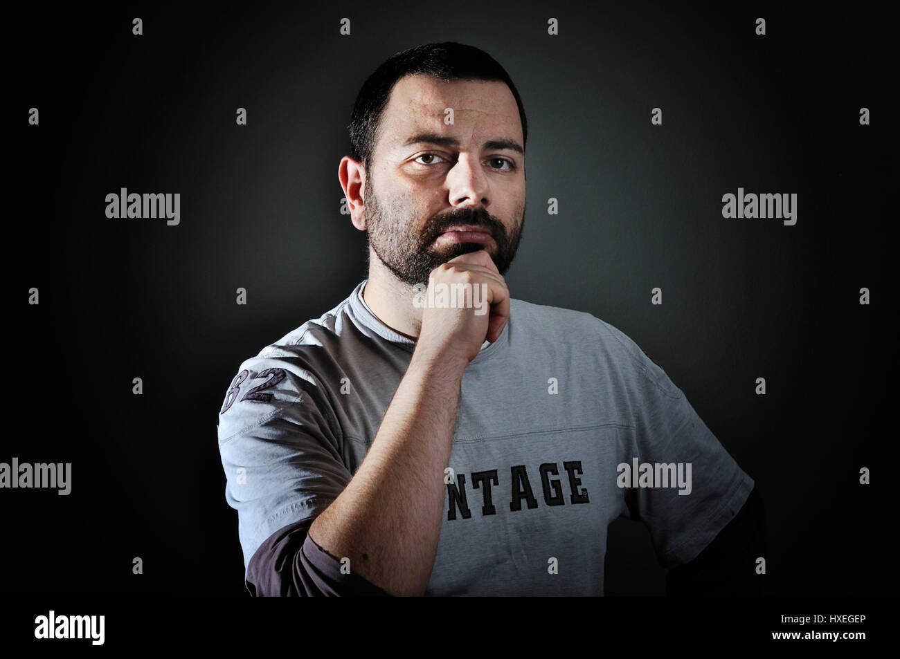 Portrait of mid adult man with hand on chin Stock Photo