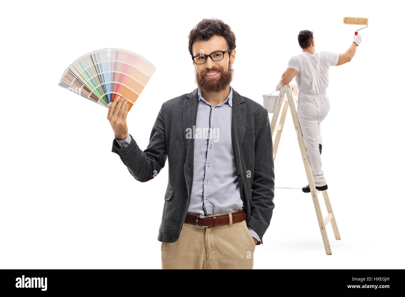 Young man holding a color swatch with a painter painting climbed up a ladder isolated on white background Stock Photo