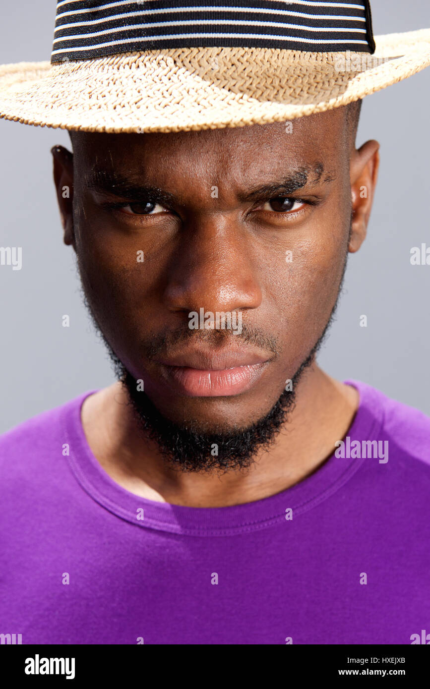 Close up portrait of a young black man with serious expression on face ...
