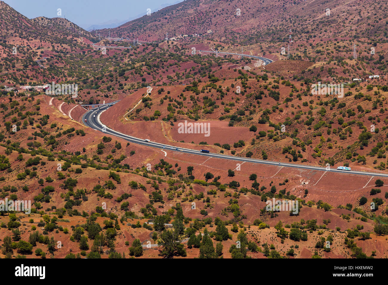 A modern highway weaves through the red terrain between Agadir & Marrakesh. Stock Photo