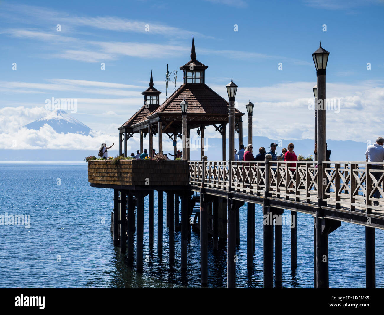 View over pier towards volcano Osorno, tourists on the pier taking pictures, village Frutilliar, at lake lago llanquihue, chilenean lake district, Chi Stock Photo