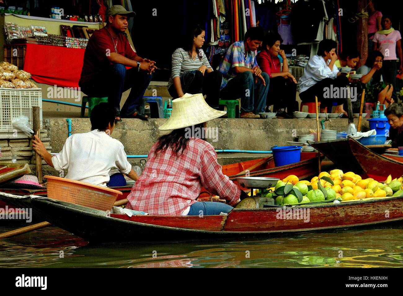 Damnoen Saduak, Thailand - December 27, 2005:  Vendor selling fruits from her flat bottomed wooden boat at the Damnoen Saduak Floating Market Stock Photo