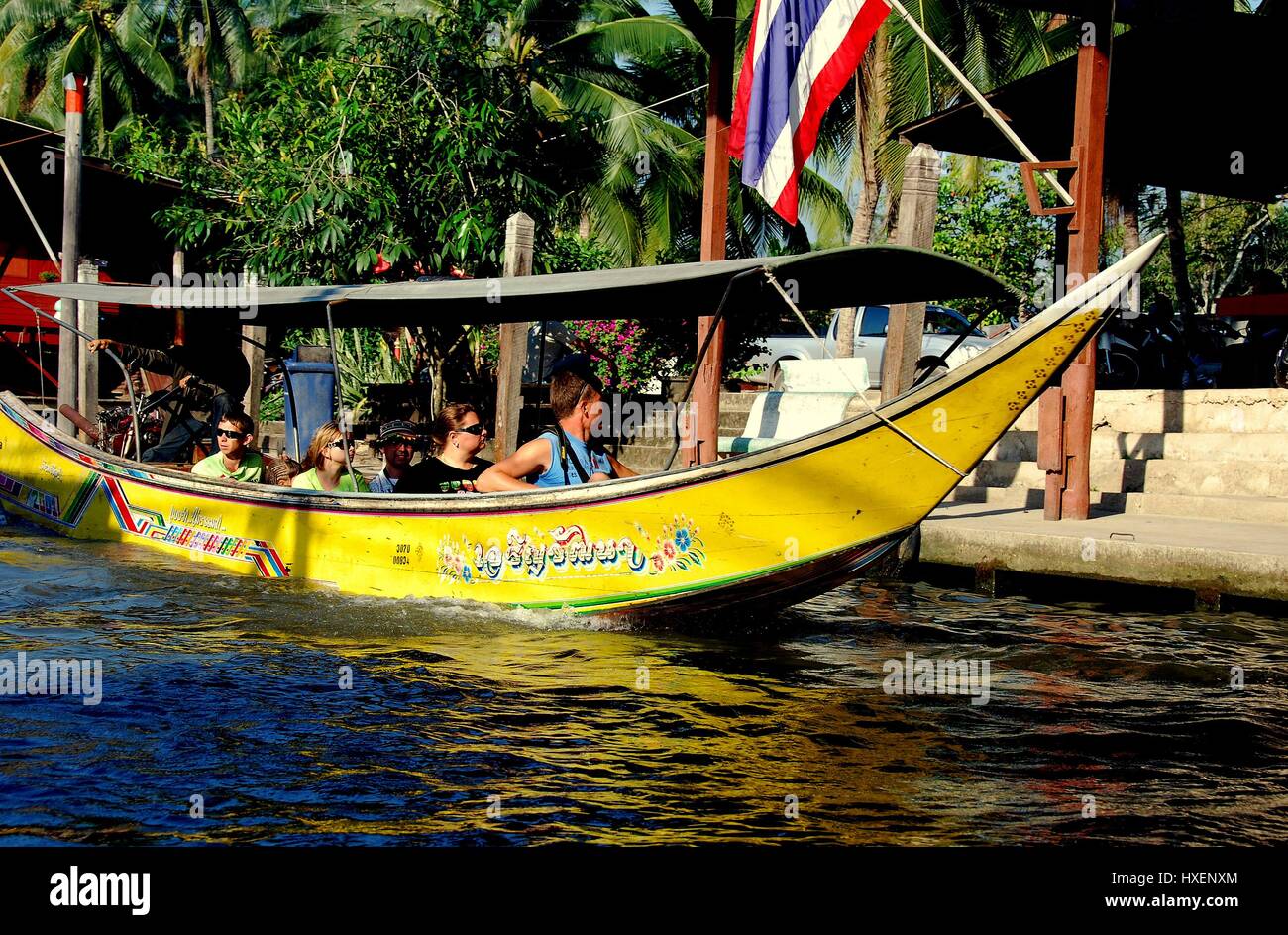 Damnoen Saduak, Thailand - January 9, 2010:   A covered long boat takes tourists for a ride through the canals of the famous Floating Market    * Stock Photo