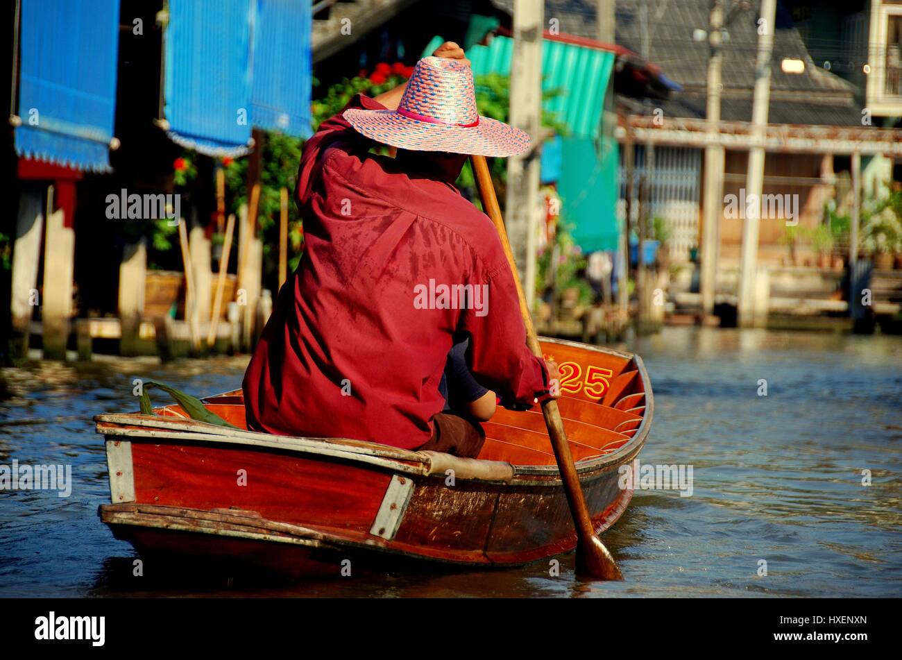 Damnoen Saduak, Thailand - January 9, 2010:    Boatman paddles his wooden boat along a canal at the Damnoen Saduak Floating Market  * Stock Photo