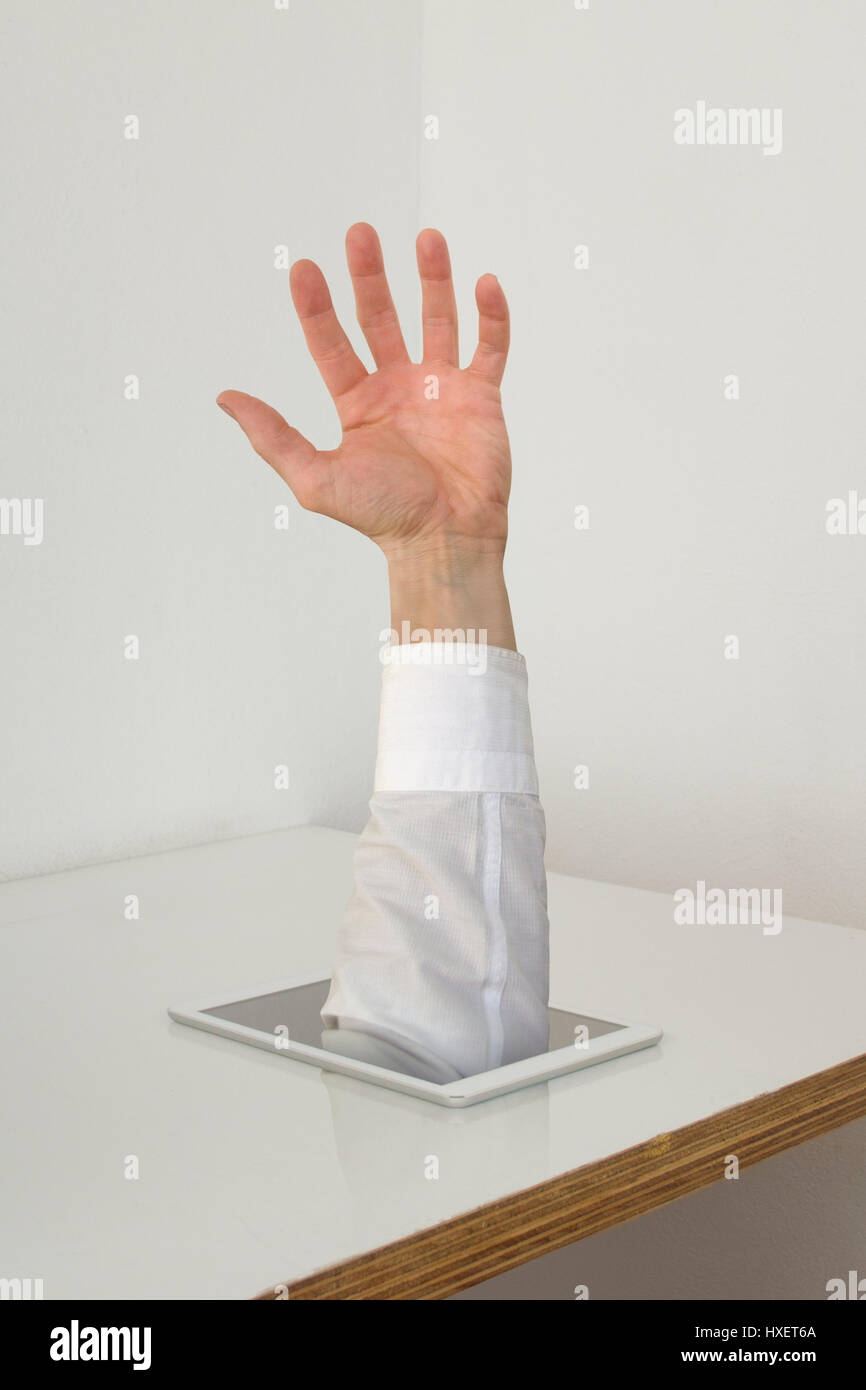 A man's hand gets out of a white tablet Stock Photo
