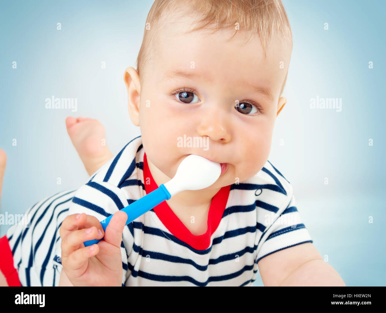 Nine month old baby lying in the bed with spoon Stock Photo Alamy