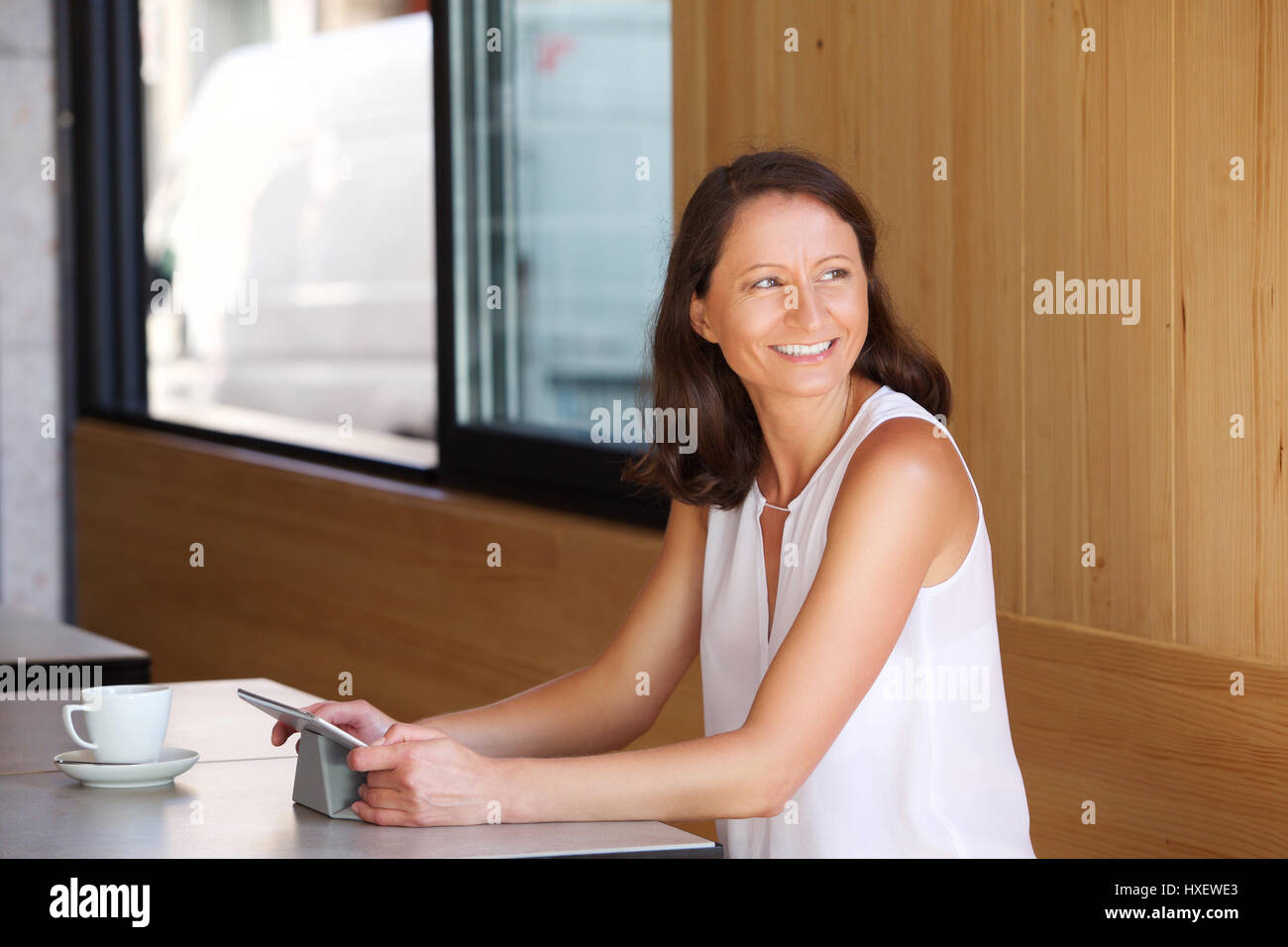 Happy smiling woman sitting at restaurant with tablet Stock Photo - Alamy