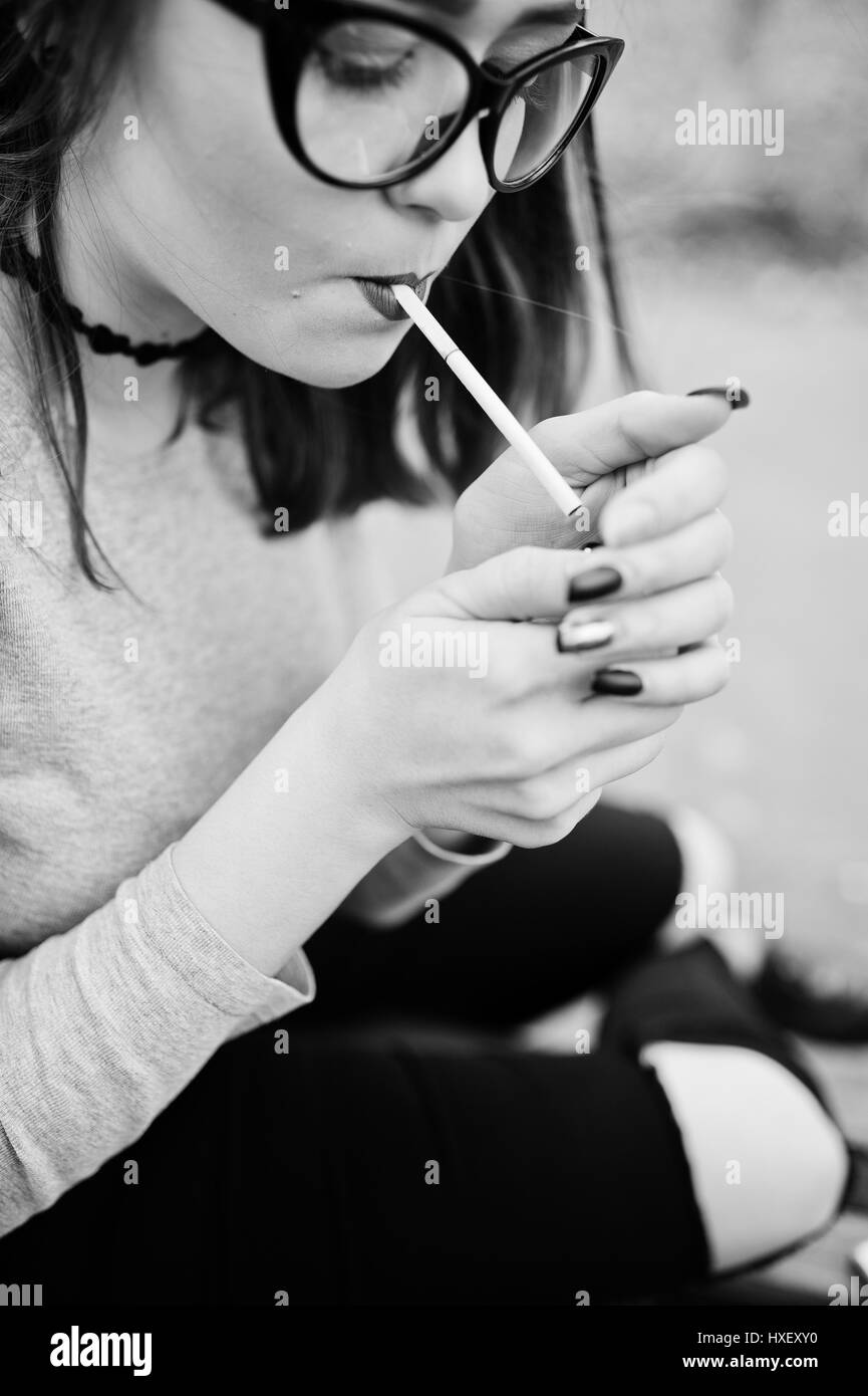 Young girl lighting cigarette outdoors close up. Concept of nicotine addiction by teenagers. Stock Photo