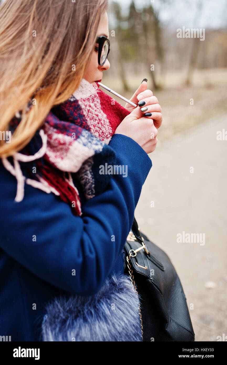 Young girl lighting cigarette outdoors close up. Concept of nicotine addiction by teenagers. Stock Photo