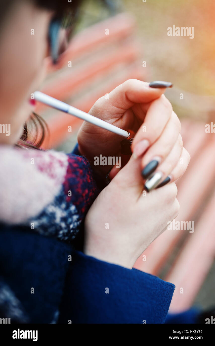 Young girl lighting cigarette outdoors close up. Concept of nicotine addiction by teenagers. Stock Photo
