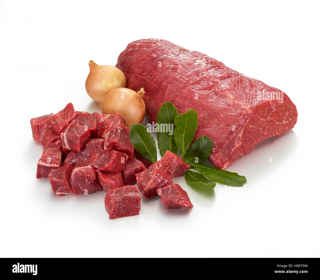 Raw beef stew, beef, bay leaves (Laurus nobilis), onion (Allium cepa) as decoration Stock Photo