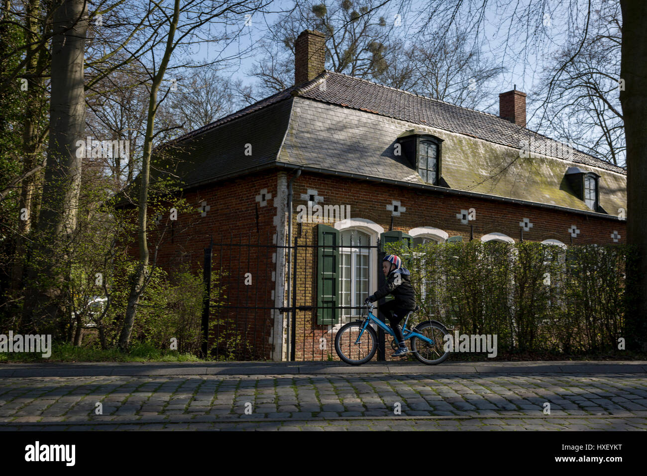 A young boy cycles past the gamekeeper’s house at the entrance of