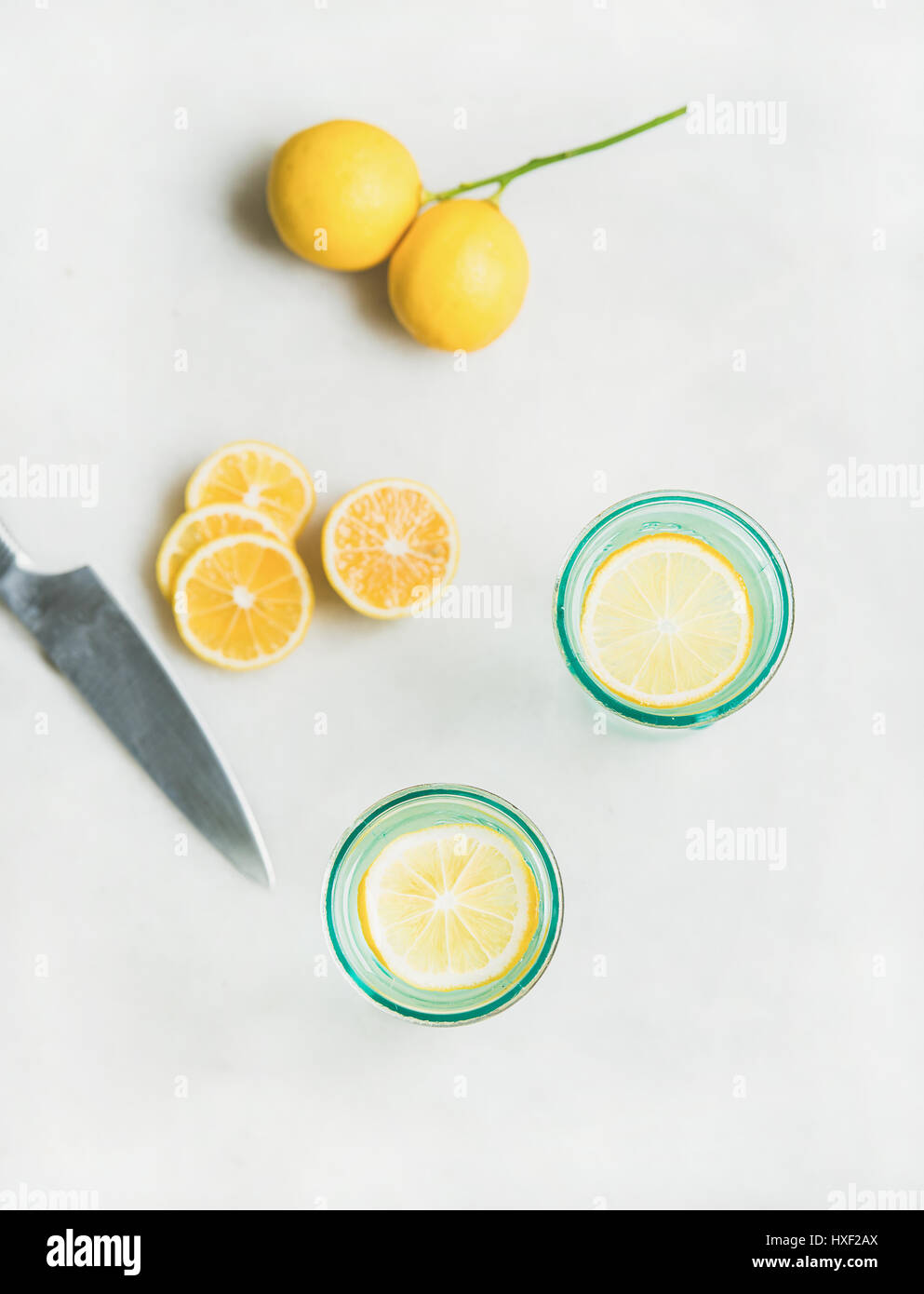Detox lemon water in glasses and fresh lemons, top view Stock Photo