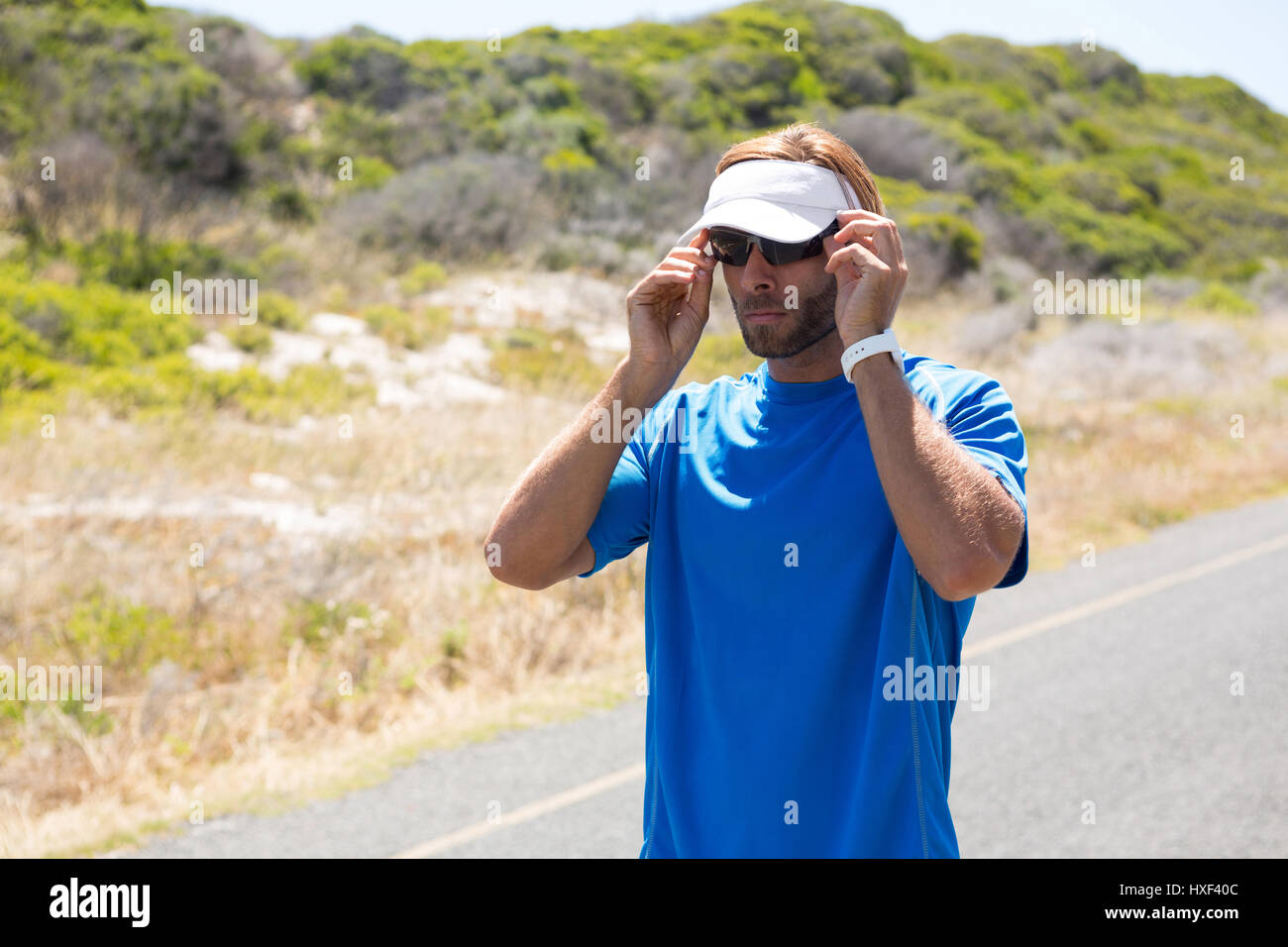 Confident sportsman wearing sunglasses on road Stock Photo