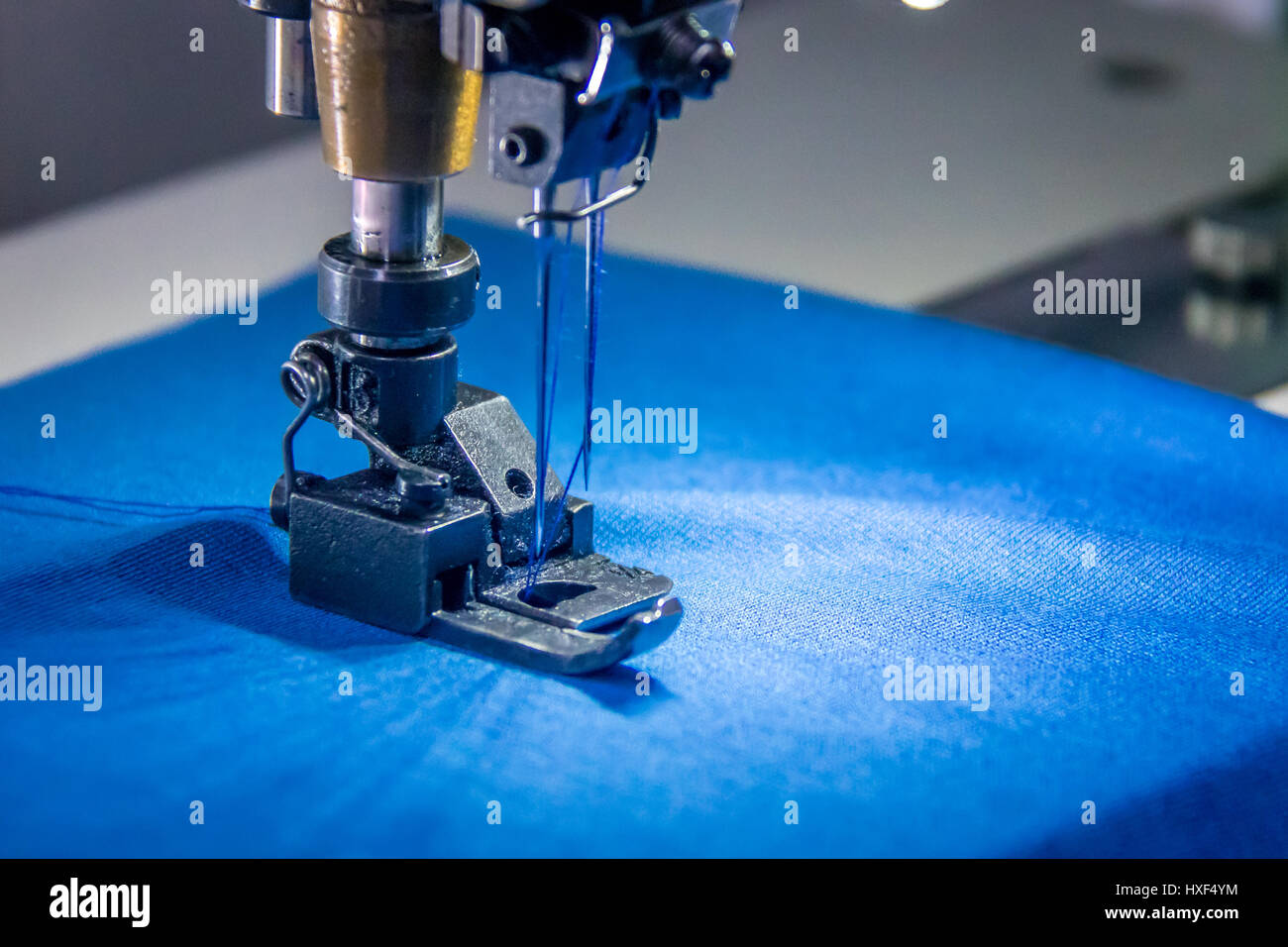 Professional overlock sewing machine with blue fabric Stock Photo