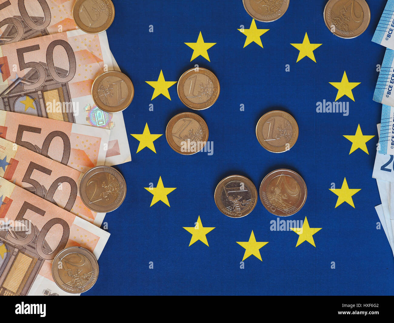 Euro banknotes and coins (EUR), currency of European Union over flag of ...